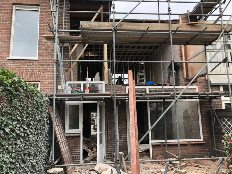 Achtergevel in ruwbouw met steiger tijdens een uitbouw