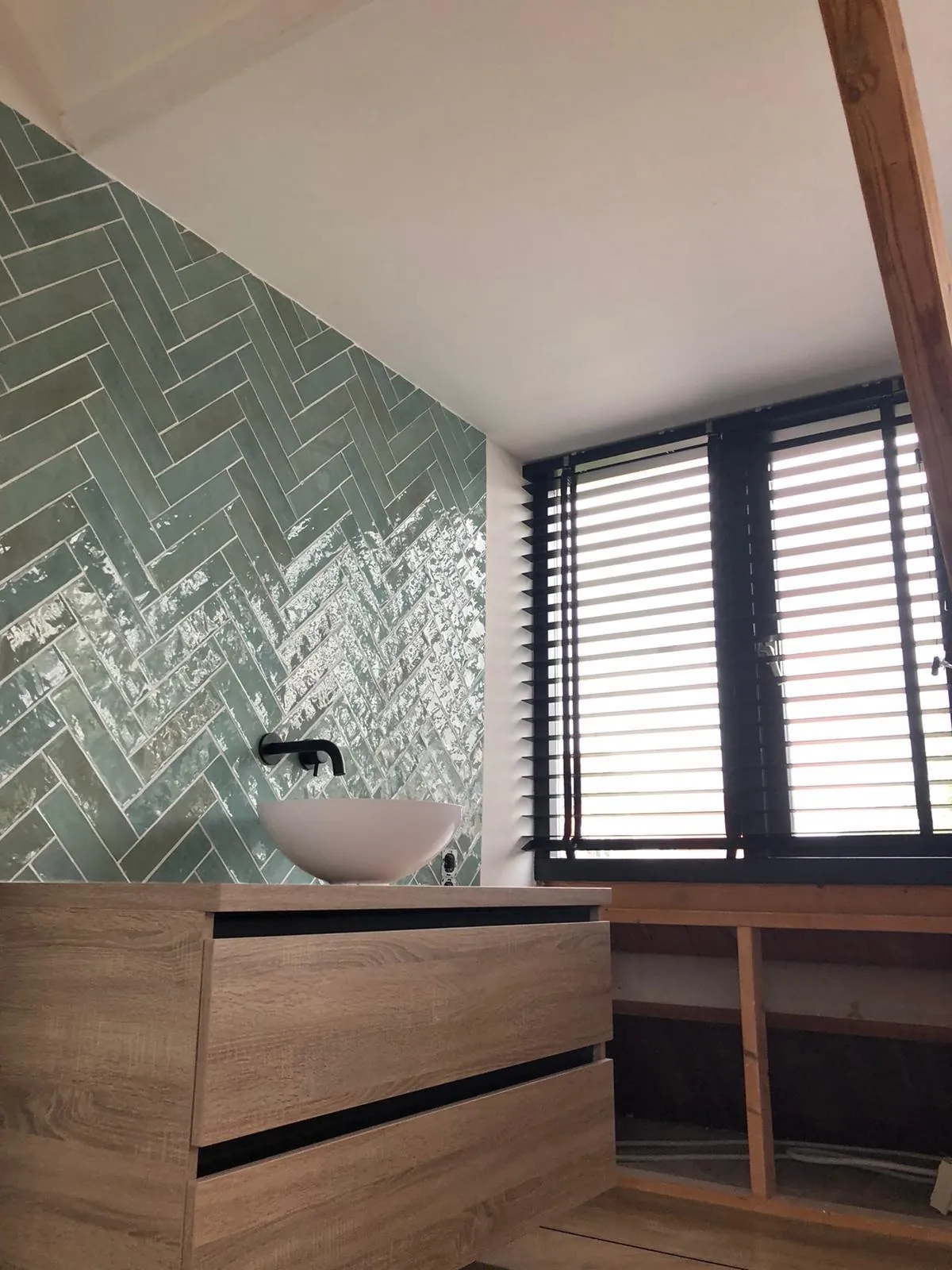 Badkamer met groen visgraat tegelwerk, gezet door onze eigen tegelzetters in Haarlem