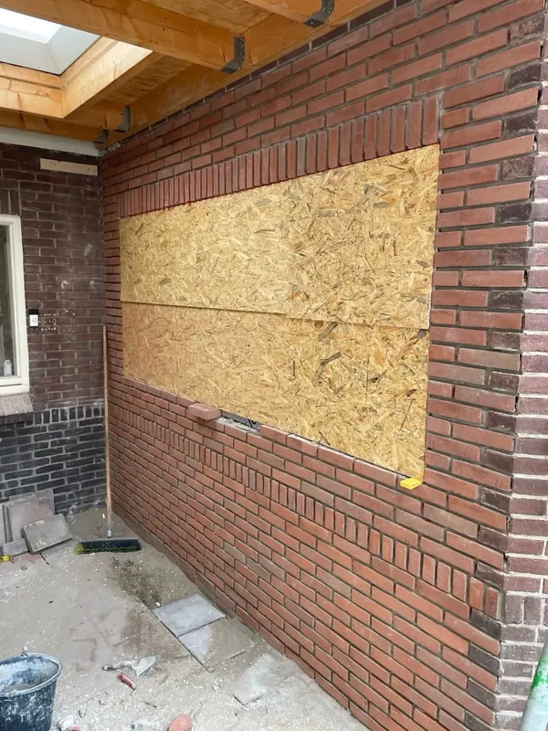 Doorbraak in metselwerk met herstel van de gevel