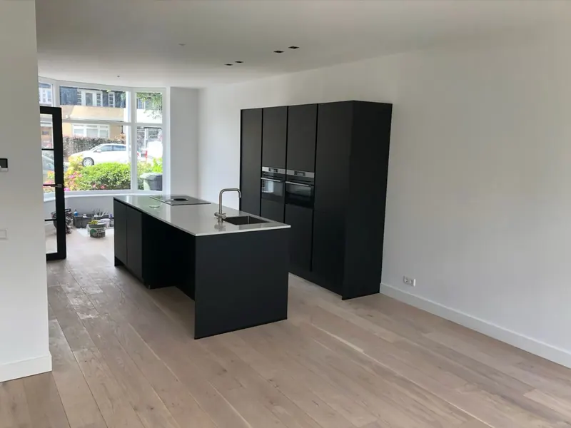 Zwarte keuken met eiland op een eiken vloer