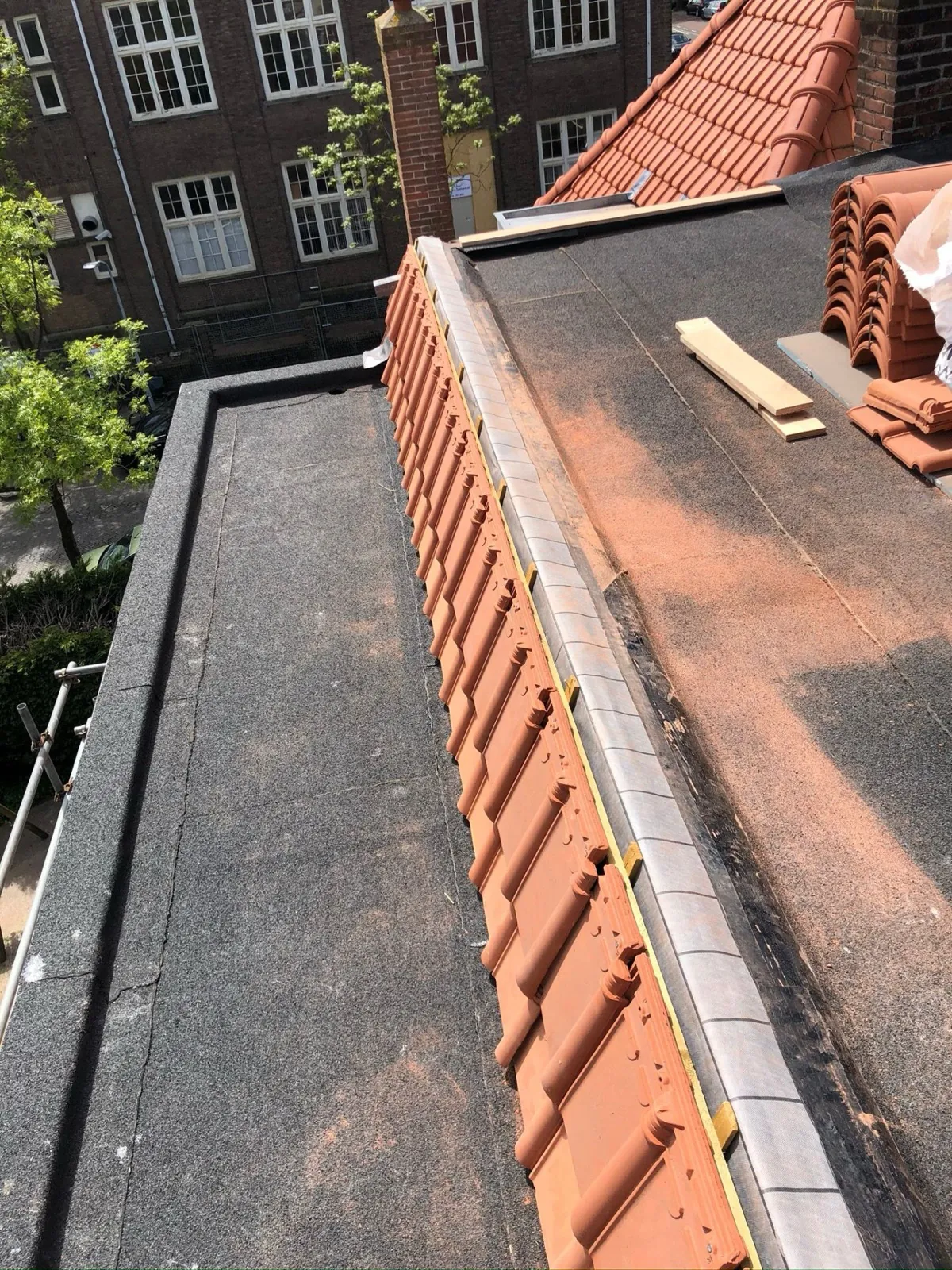 Dakdekker legt nokvorsten en nieuwe dakpannen op een woning in Haarlem