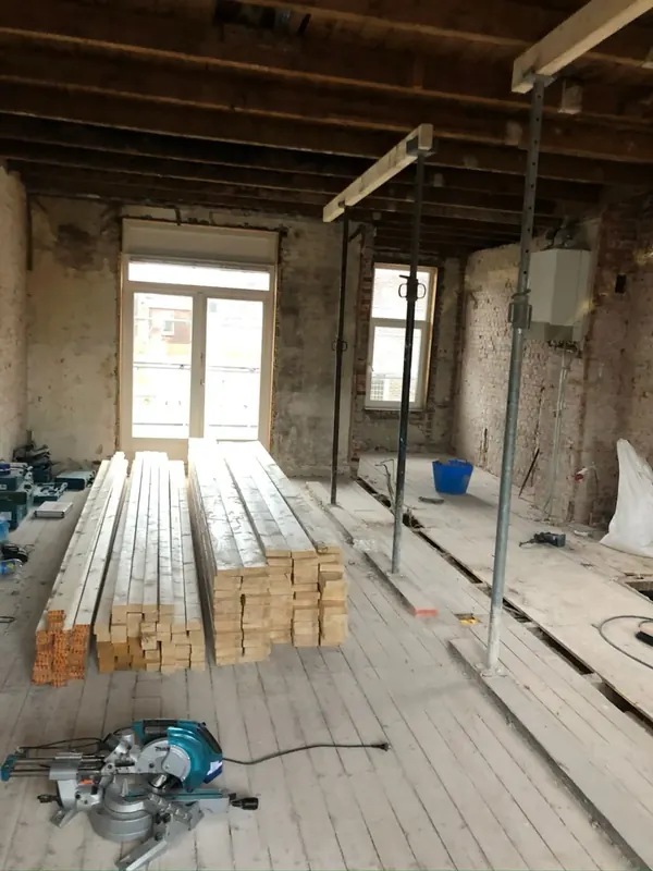Vloer op stempels met houtvoorraad op de bouwplaats