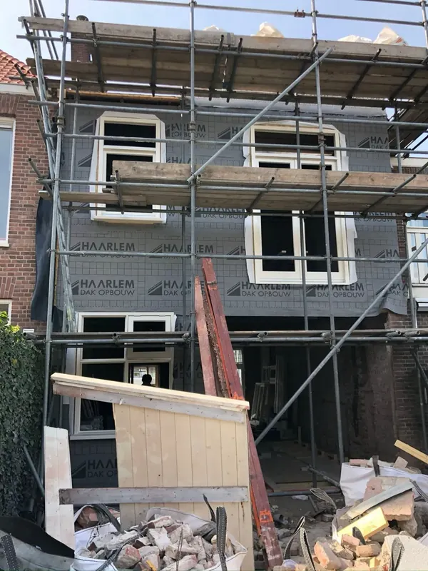 Voorgevel met dampopen folie en nieuwe kozijnen tijdens renovatie